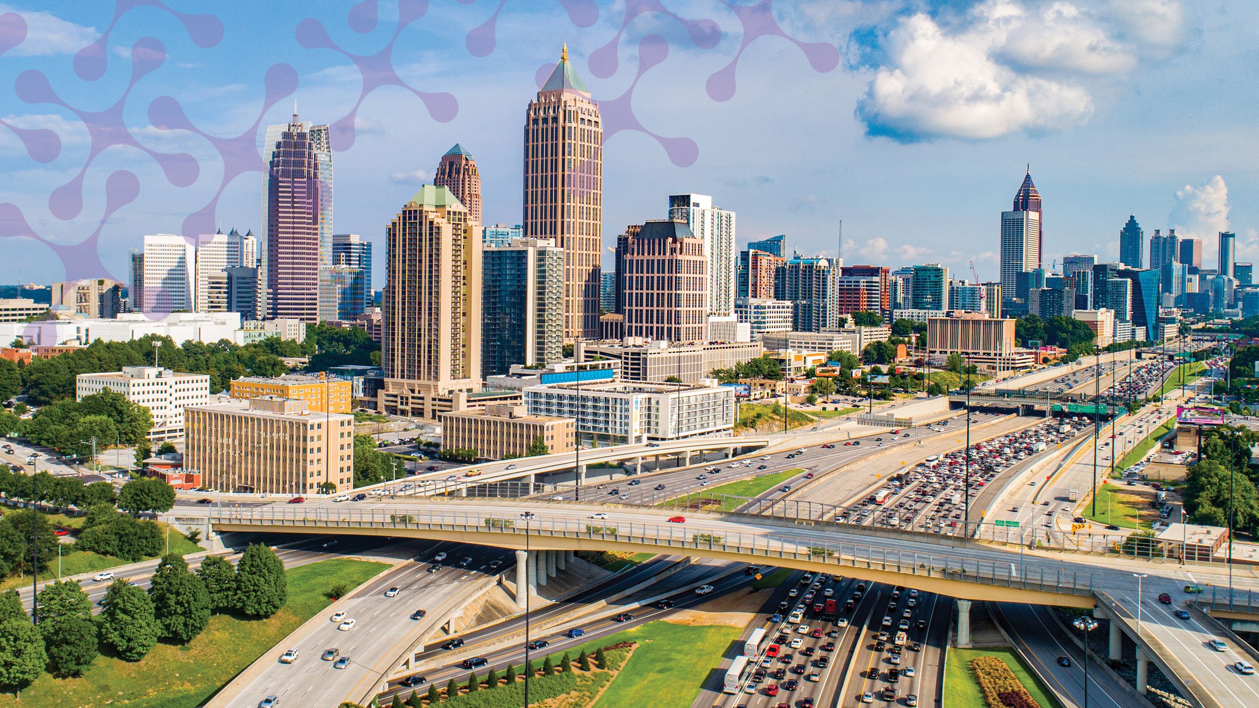 a photograph of the atlanta cityscape with a congested highway. Also has abstract molecules flying around in the corner.