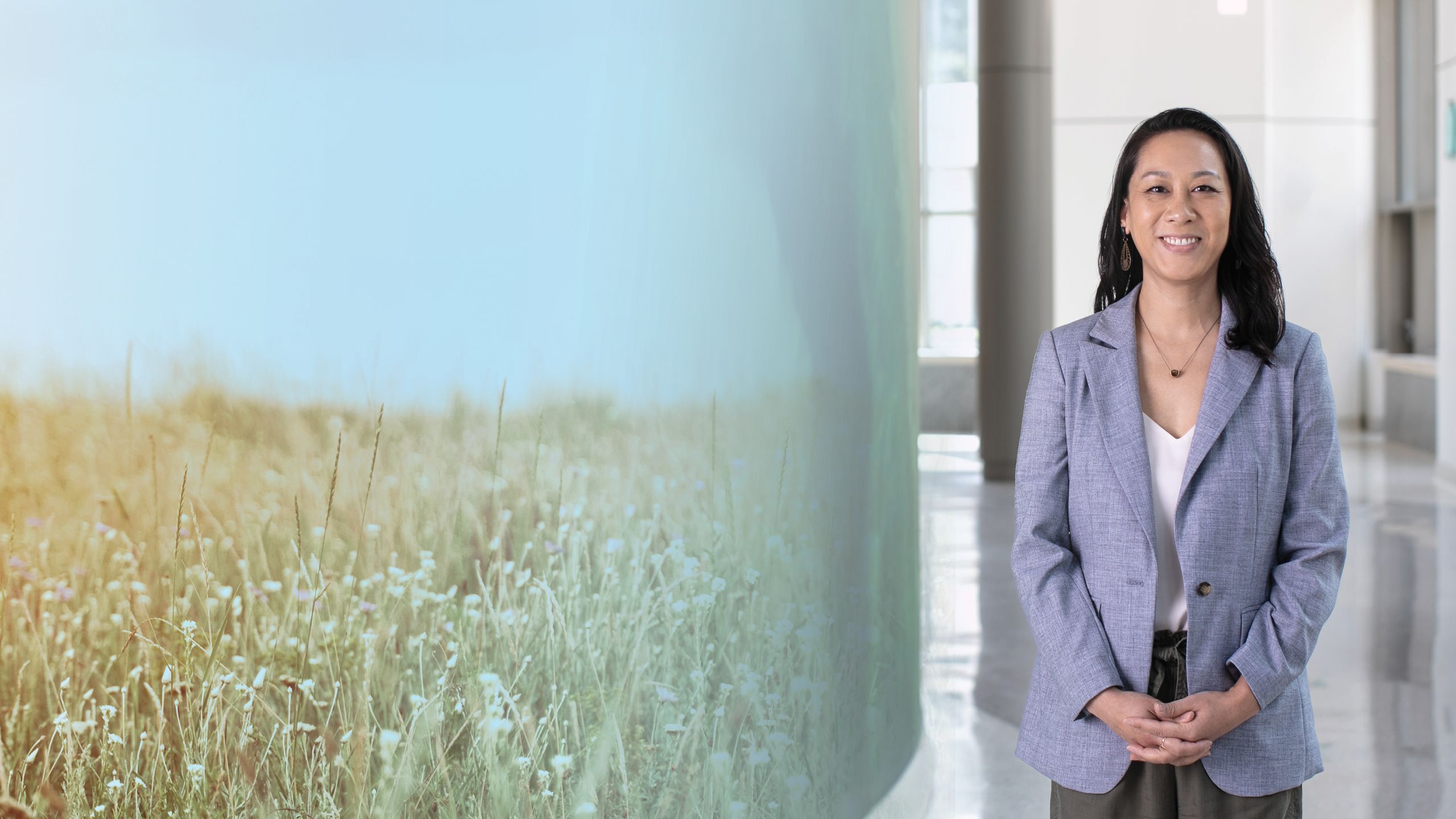 a photo illustration background of a wildflower field on the left and regina shih on the right in a building smiling to the camera.