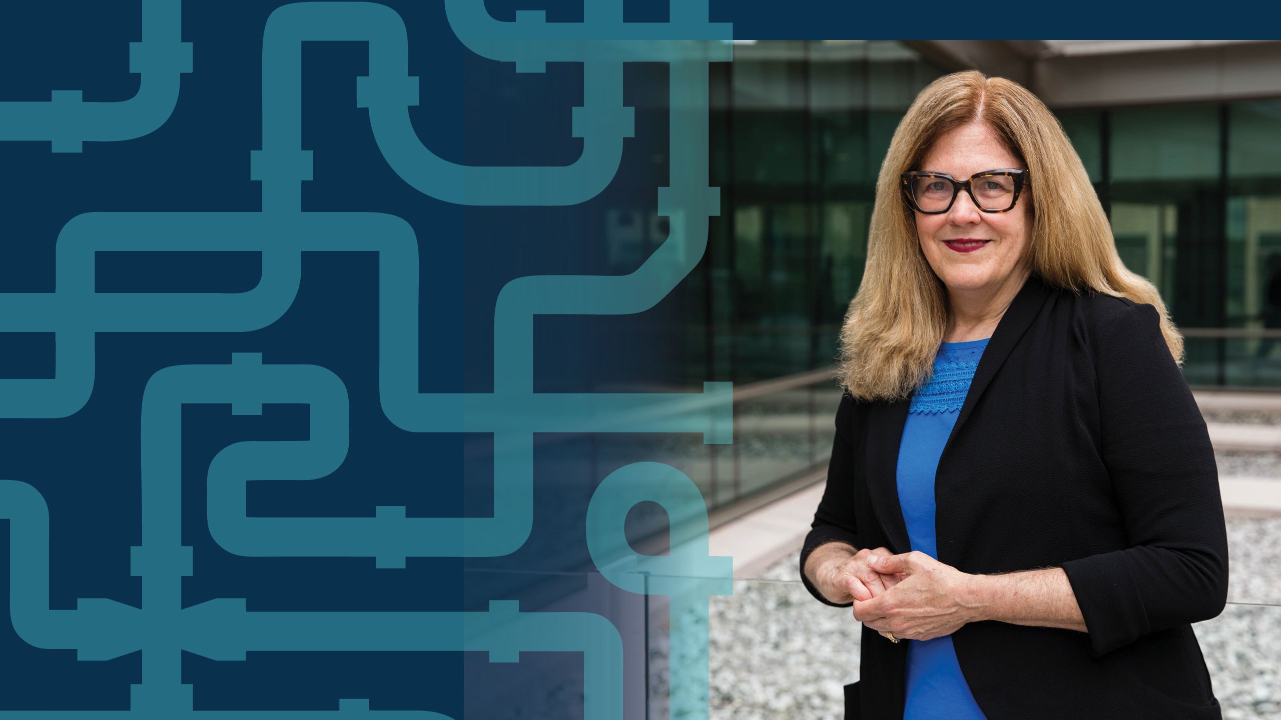 a portrait of Anne Spaulding standing in front of glass building