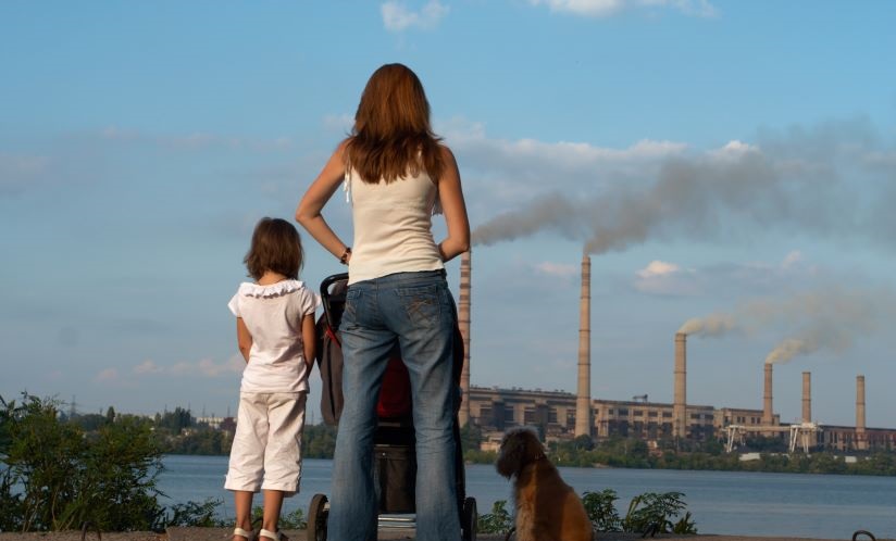 A family looks at smoke stacks.