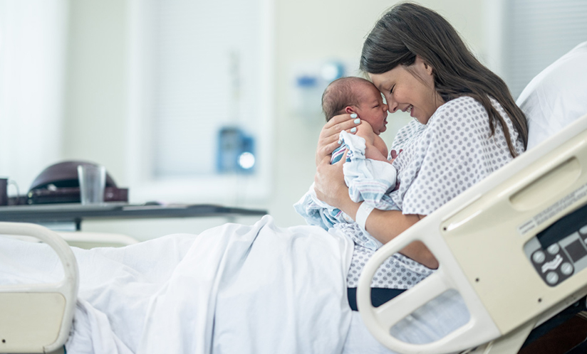 Mother holding newborn baby in hospital