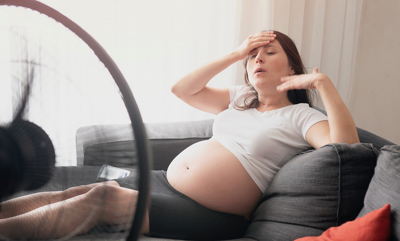 pregnant woman on the couch reacting to the heat