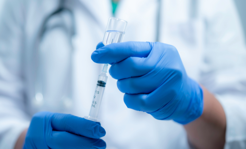 Scientist sucking vaccine into a syringe