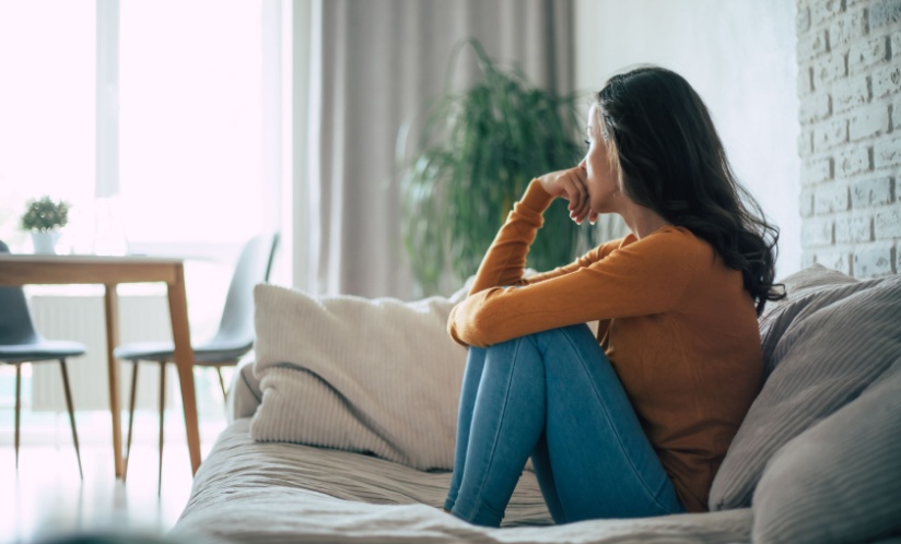 Woman sitting on a couch looking away from the camera