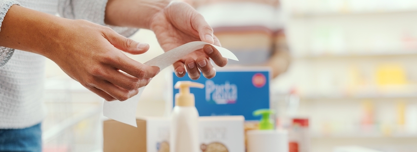 Woman reading receipt at grocery check-out