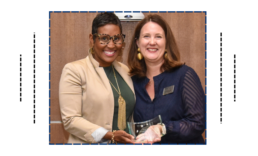 Two women holding an award