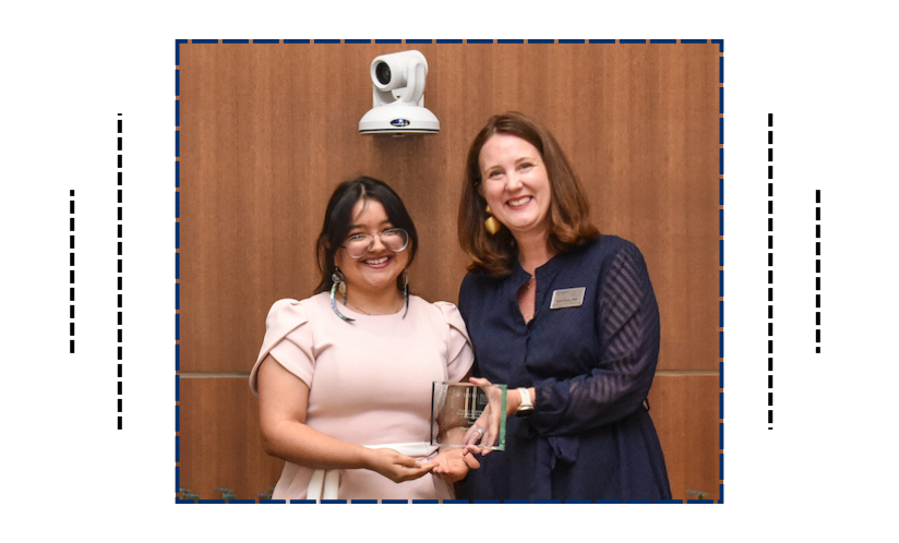 Two women holding an award