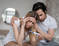 Woman and man looking at pregnancy test concerned