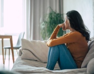 Woman sitting on a couch looking away from the camera