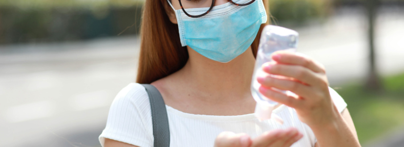 Wearing a mask and putting on hand santiizer