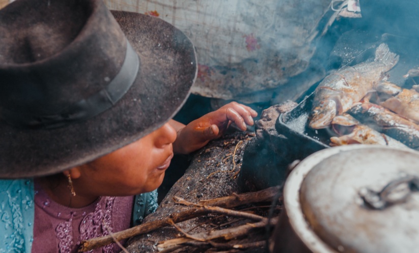 A woman cooking on a wood-burning stove