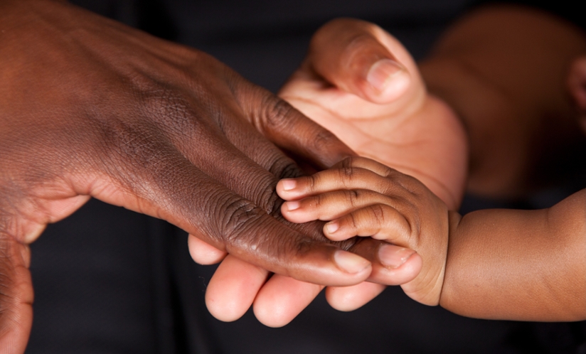 mother and infant holding hands