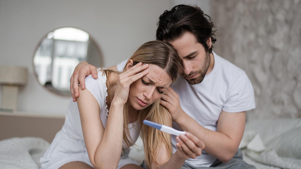 Woman and man looking at pregnancy test concerned