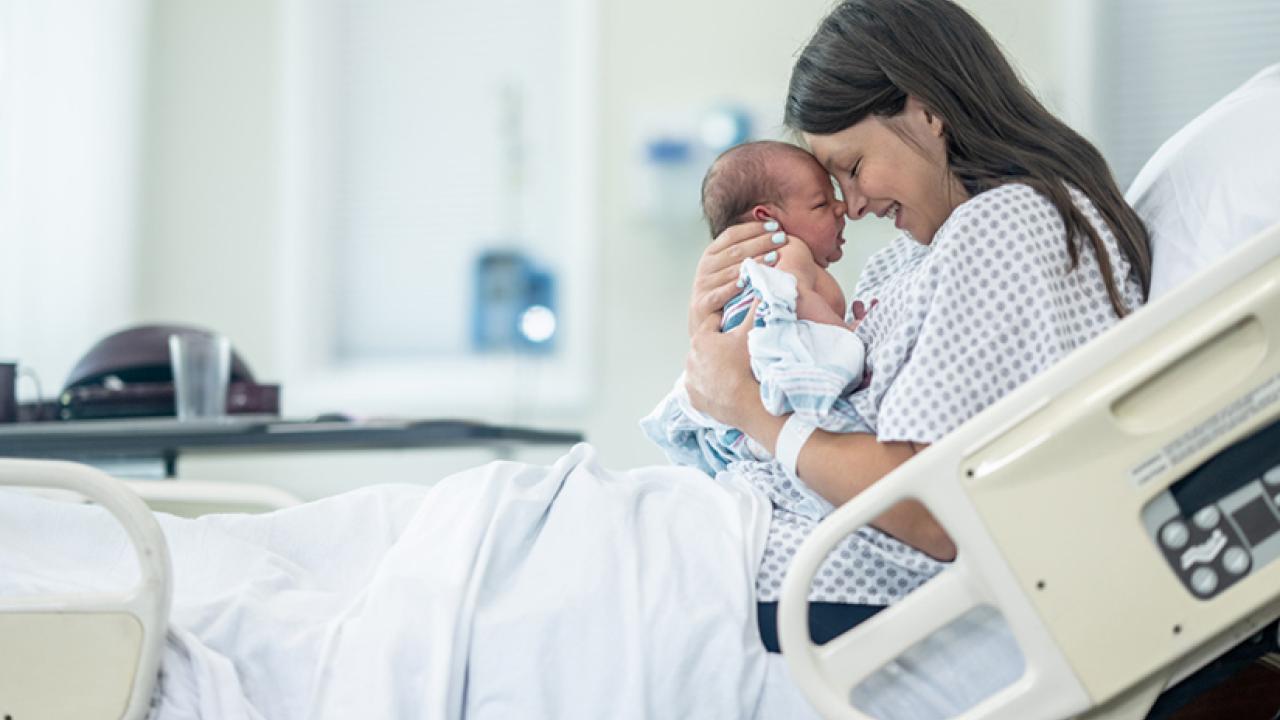Mother holding newborn baby in hospital