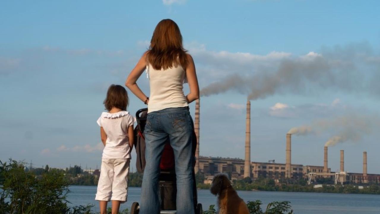 A family looks at smoke stacks.