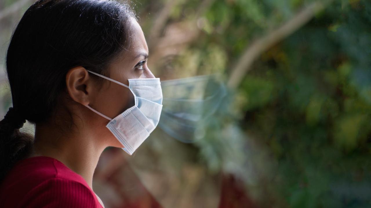 woman looking out a woman wearing a mask during COVID