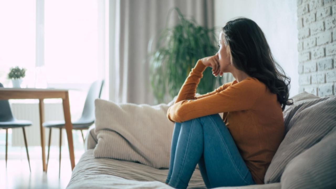 Woman sitting on a couch looking away from the camera