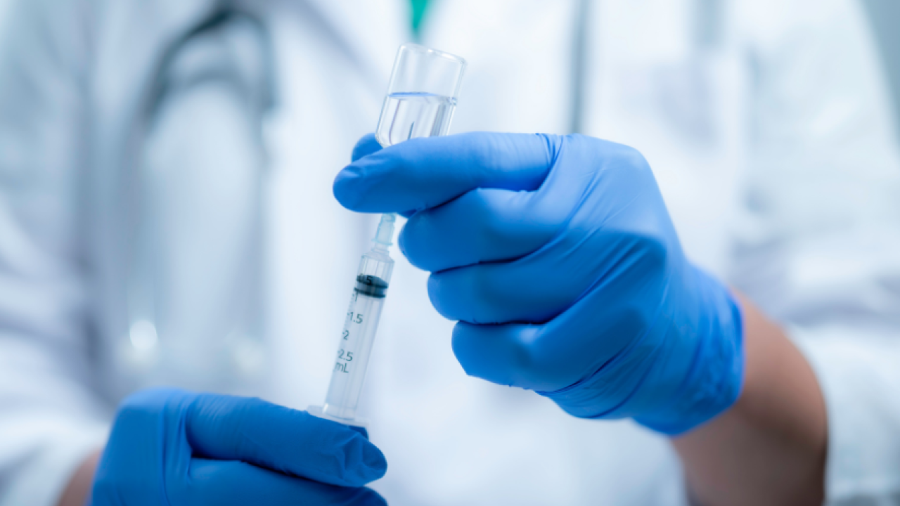 Scientist sucking vaccine into a syringe
