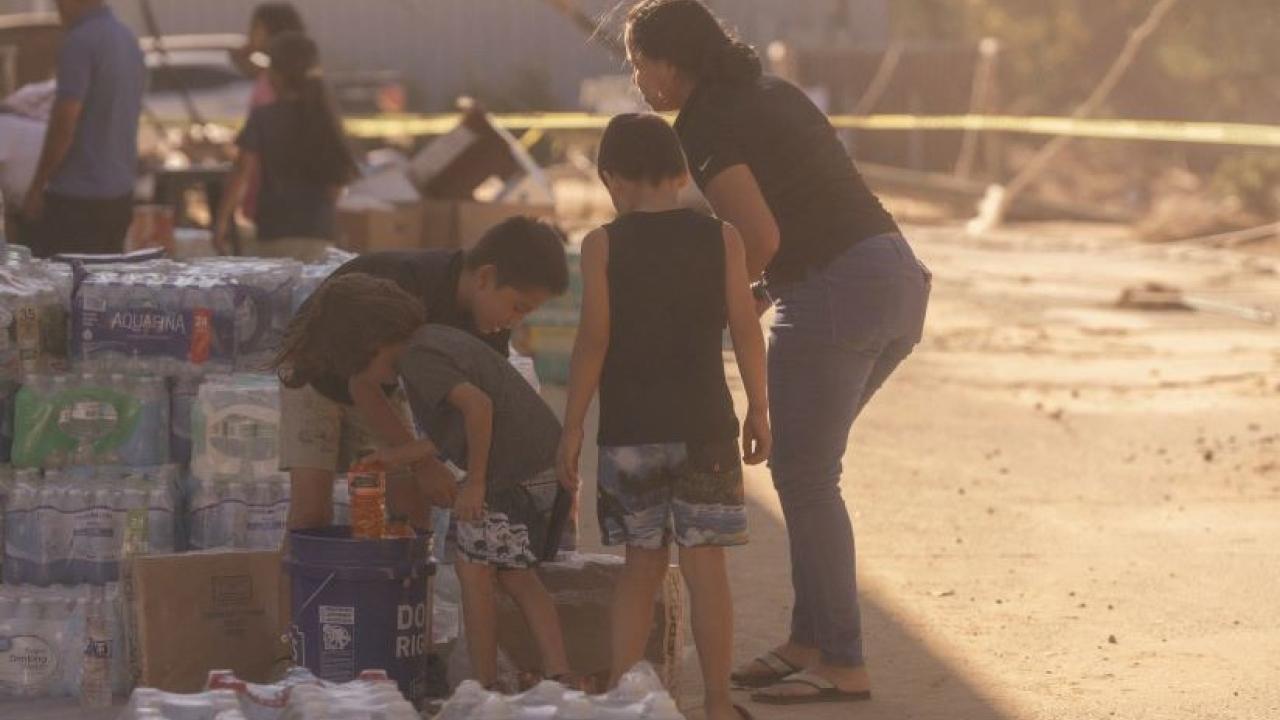 Image of a family with bottled water in the aftermath of Hurricane Helene